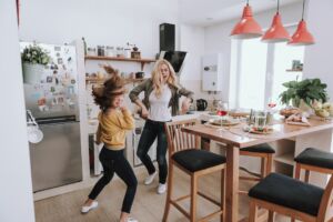 Fröhliche Mutter und Tochter haben Spaß zu Hause