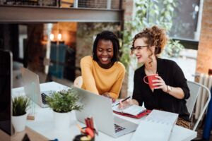 Zwei Geschäftsfrauen auf Computer im Büro arbeiten